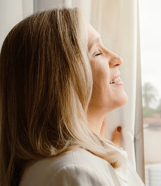 Mujer de 50 años de perfil con ojos cerrados y expresión soñadora